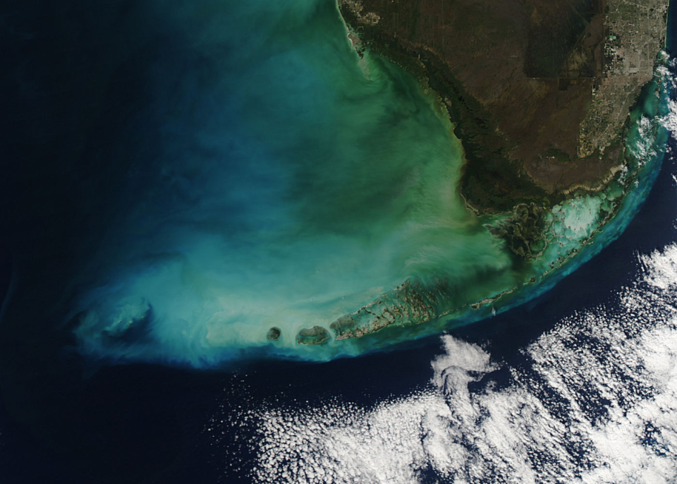 NASA’s MODIS instrument captured this image of the southern tip of Florida curving into a blue-green ocean edged by white clouds. MODIS and a new generation of satellite-based sensors can help environmental managers track noxious algae in the Gulf Coast and beyond. Credits: NASA