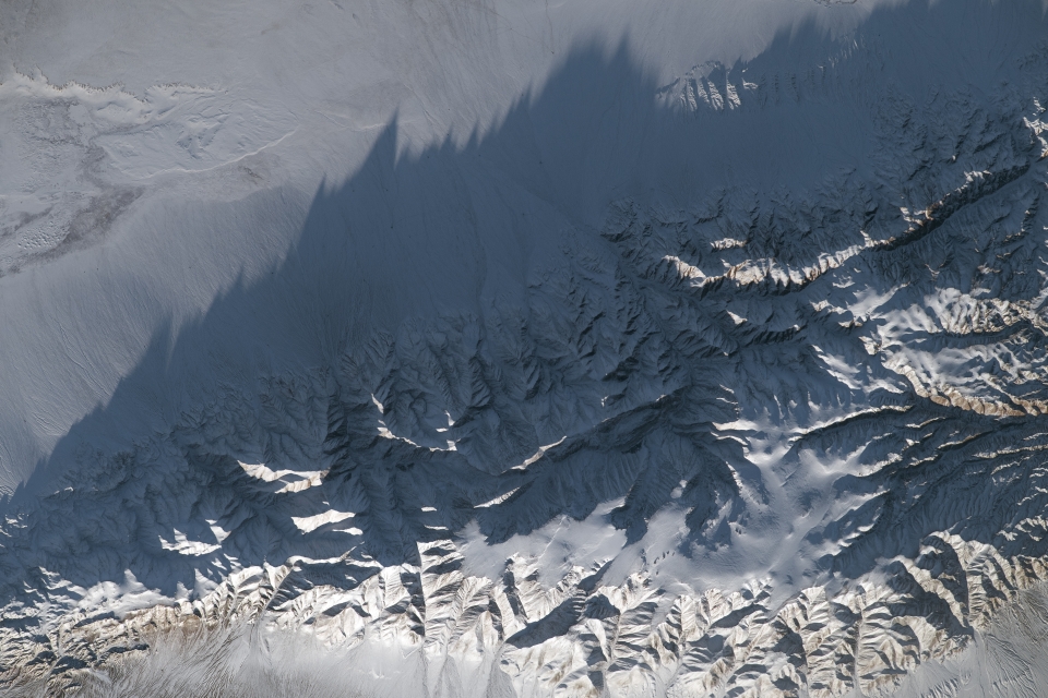 In central Asia, jagged mountain peaks rise high above the steppe.View the image at full resolution.